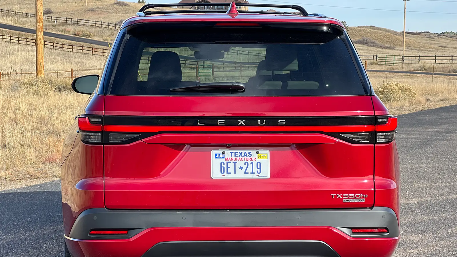 A red 2026 Lexus TX 550h+ PHEV rear view