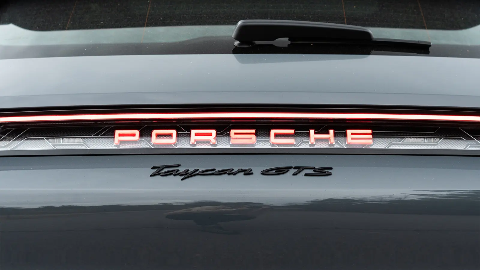 A dark gray 2025 Porsche Taycan GTS-3 emblem