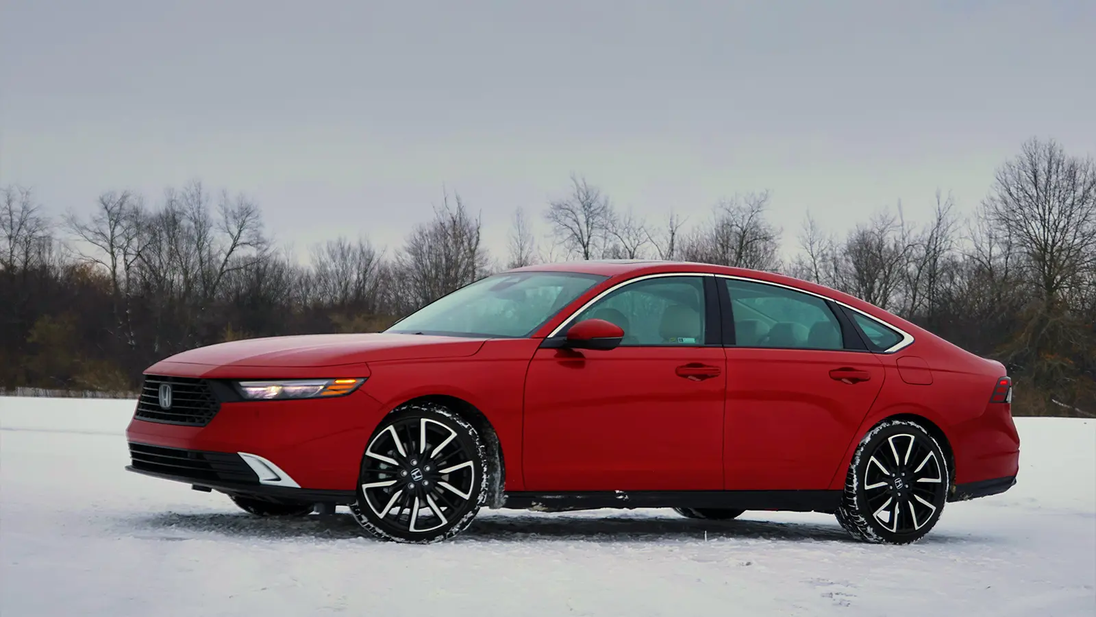 A red 2026 Honda Accord hybrid in the snow