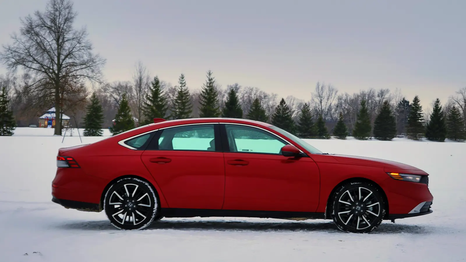 A red 2026 Honda Accord Hybrid's front view in the snow 