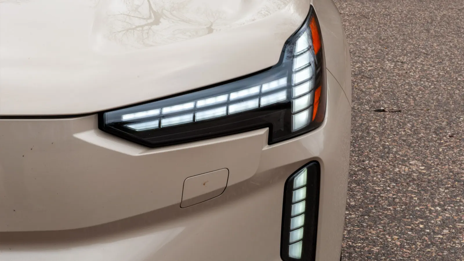A silver 2025 Volvo EX90 front nose headlight close up