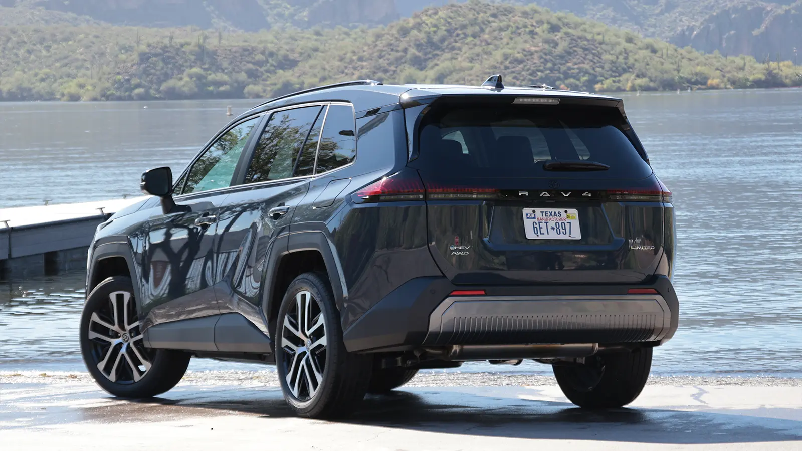 A blue 2025 Toyota RAV4 hybrid three quarter rear view