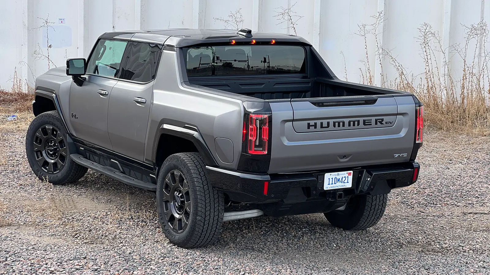 A dark gray 2026 GMC hummer EV pick up three quarter rear view