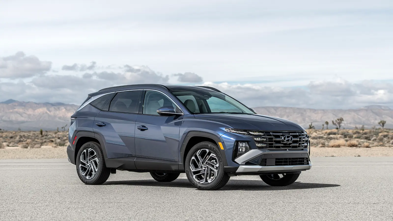 A blue 2026 Hyundai Tucson Hybrid three quarter view