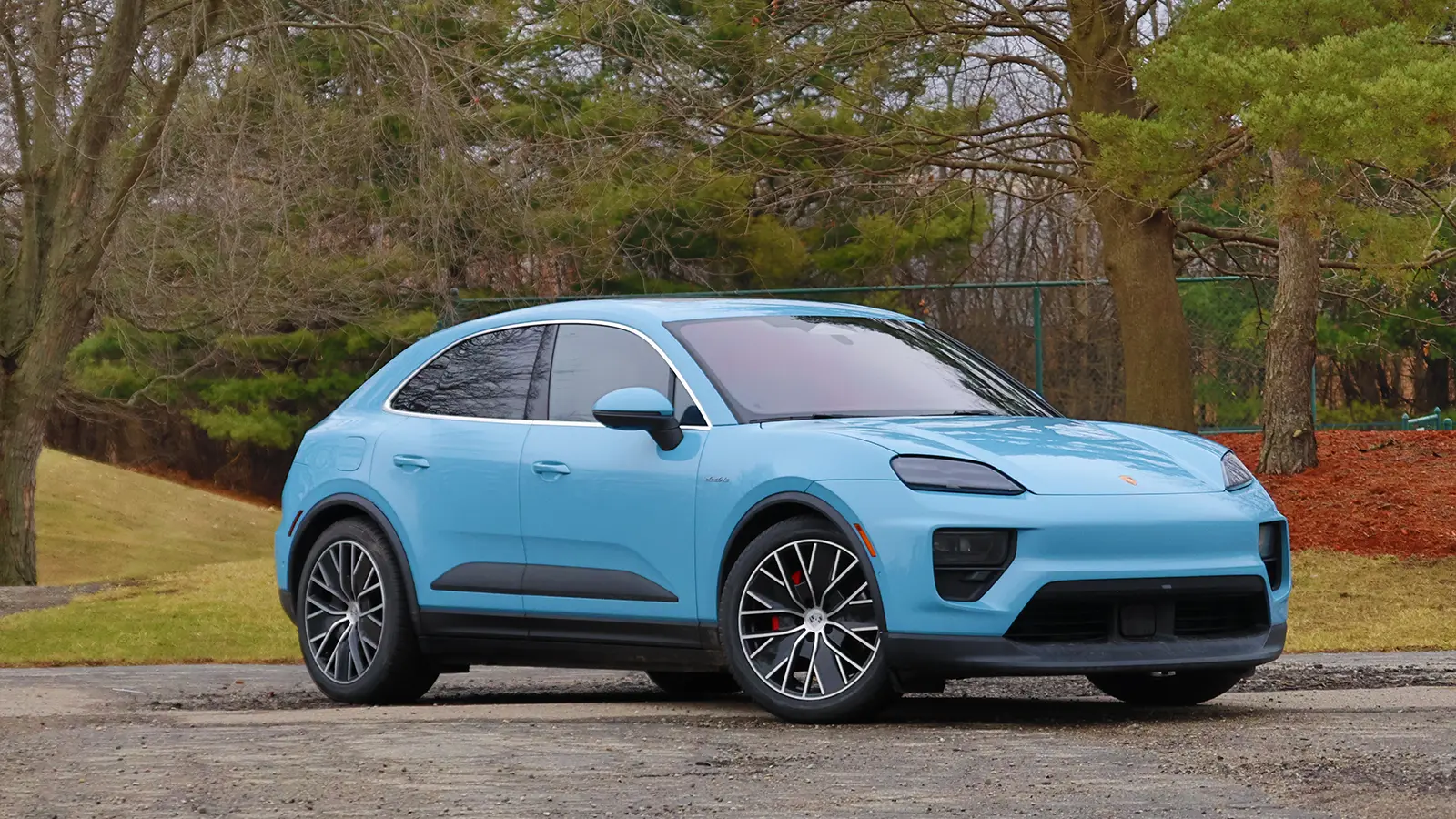 A light blue 2025 Porsche Macan 4S electric three quarter front view