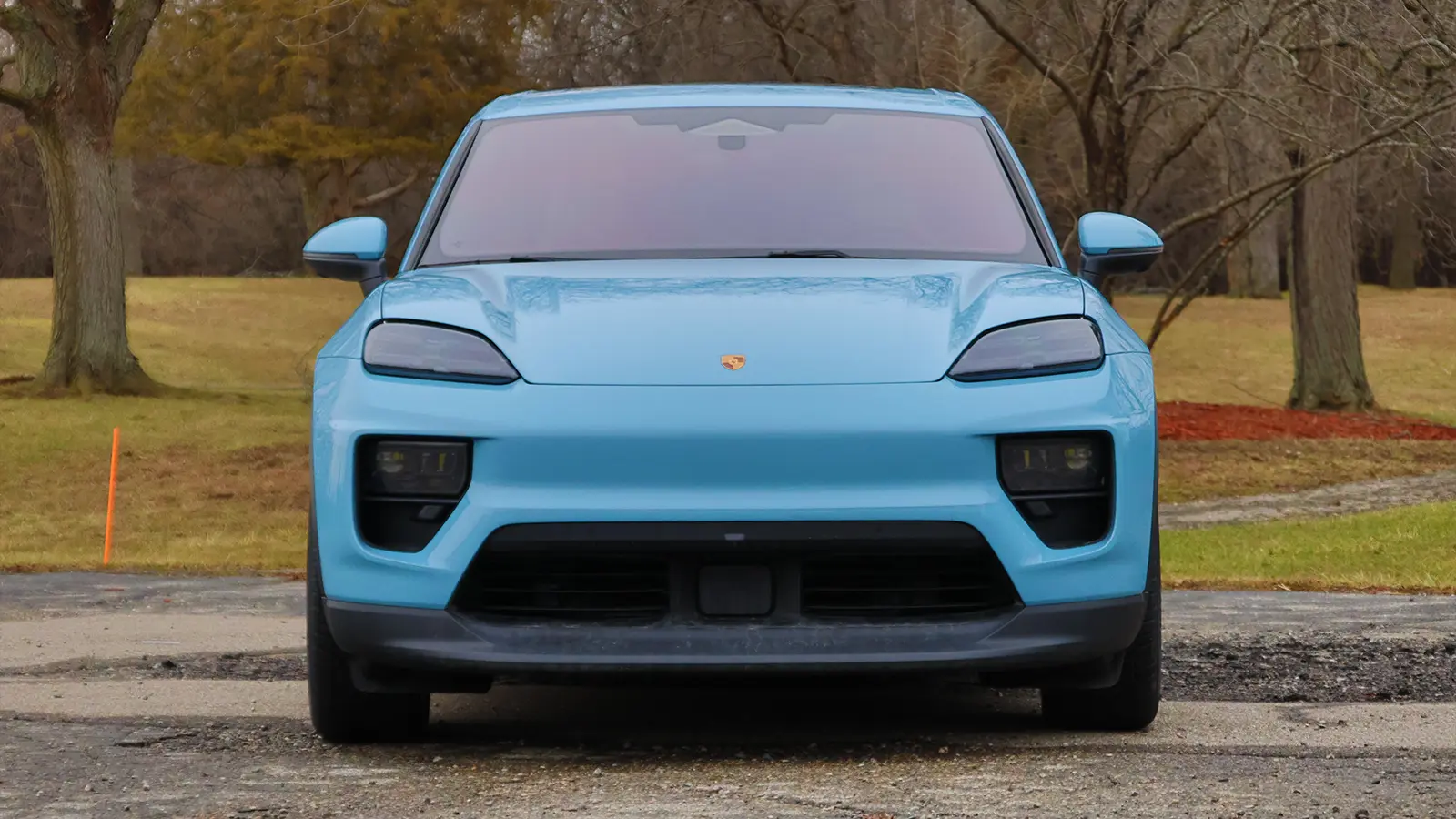 A light blue 2025 Porsche Macan 4S front nose view