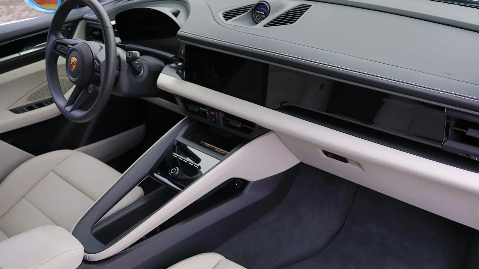 A light blue 2025 Porsche Macan 4S front driver passenger side view