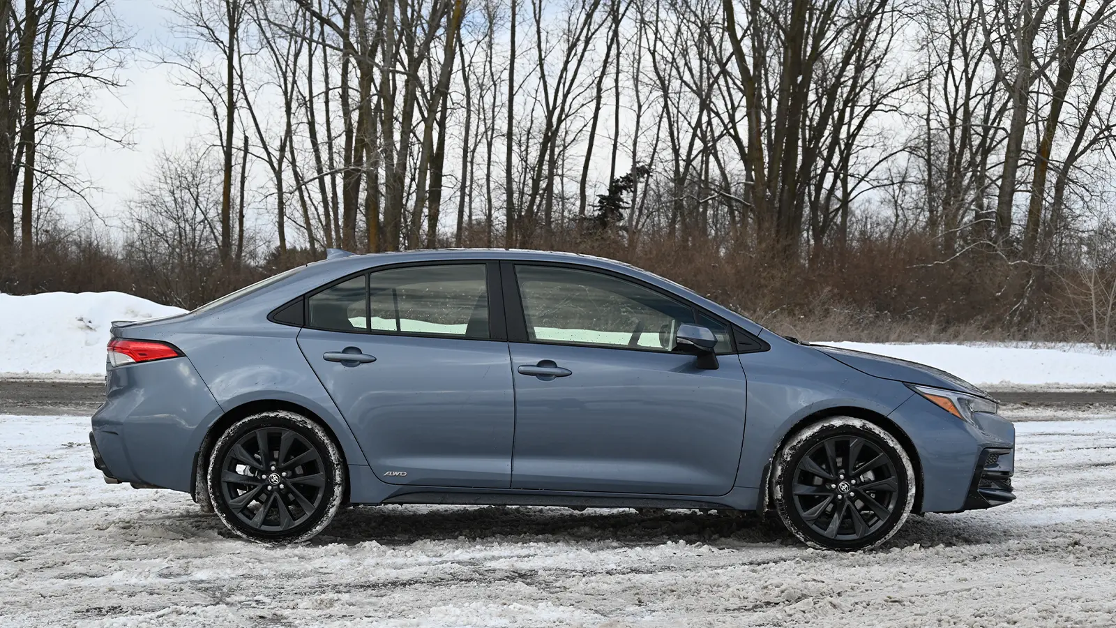 a dark blue 2026 toyota corolla hybrid side view