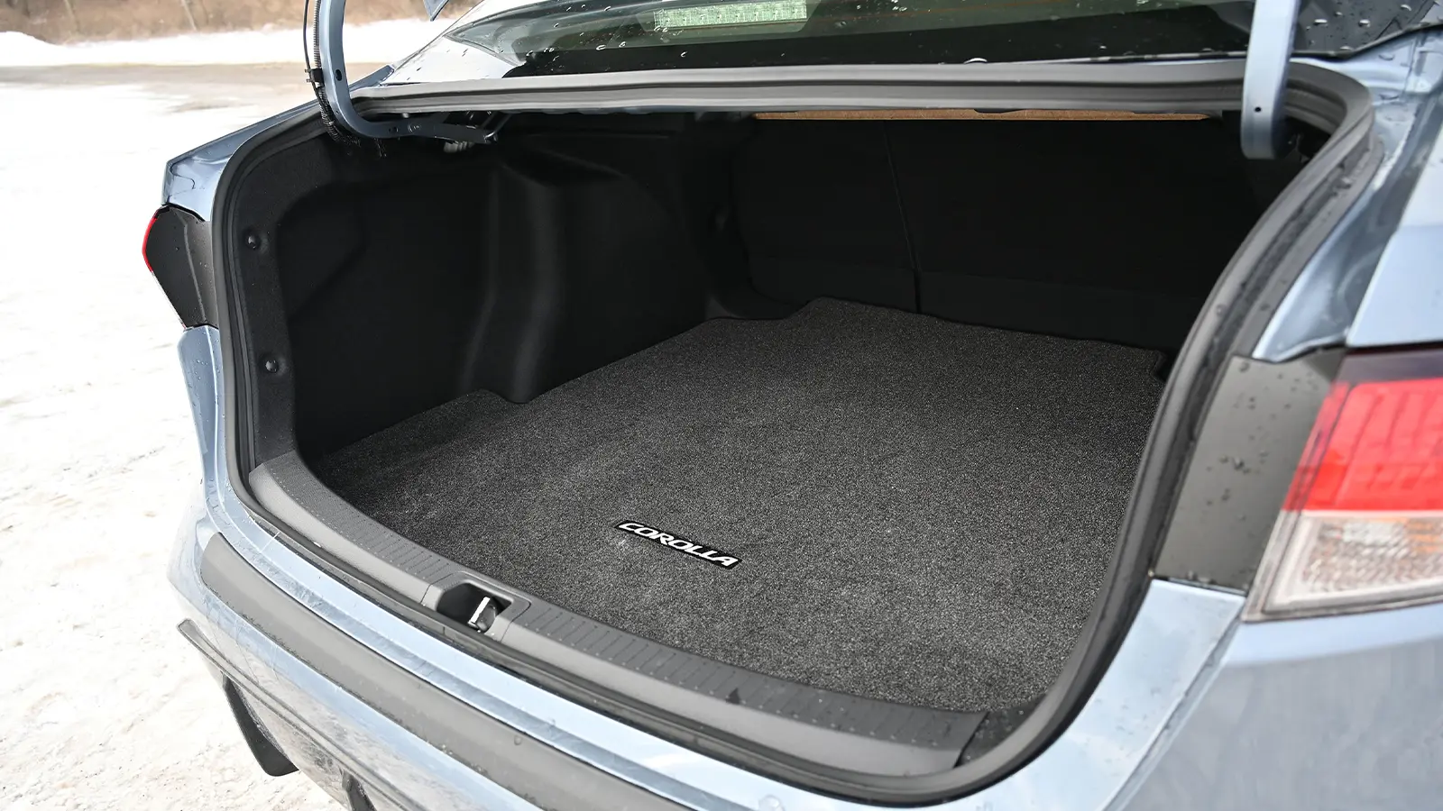 A dark blue 2026 Toyota Corolla hybrid SE rear trunk open