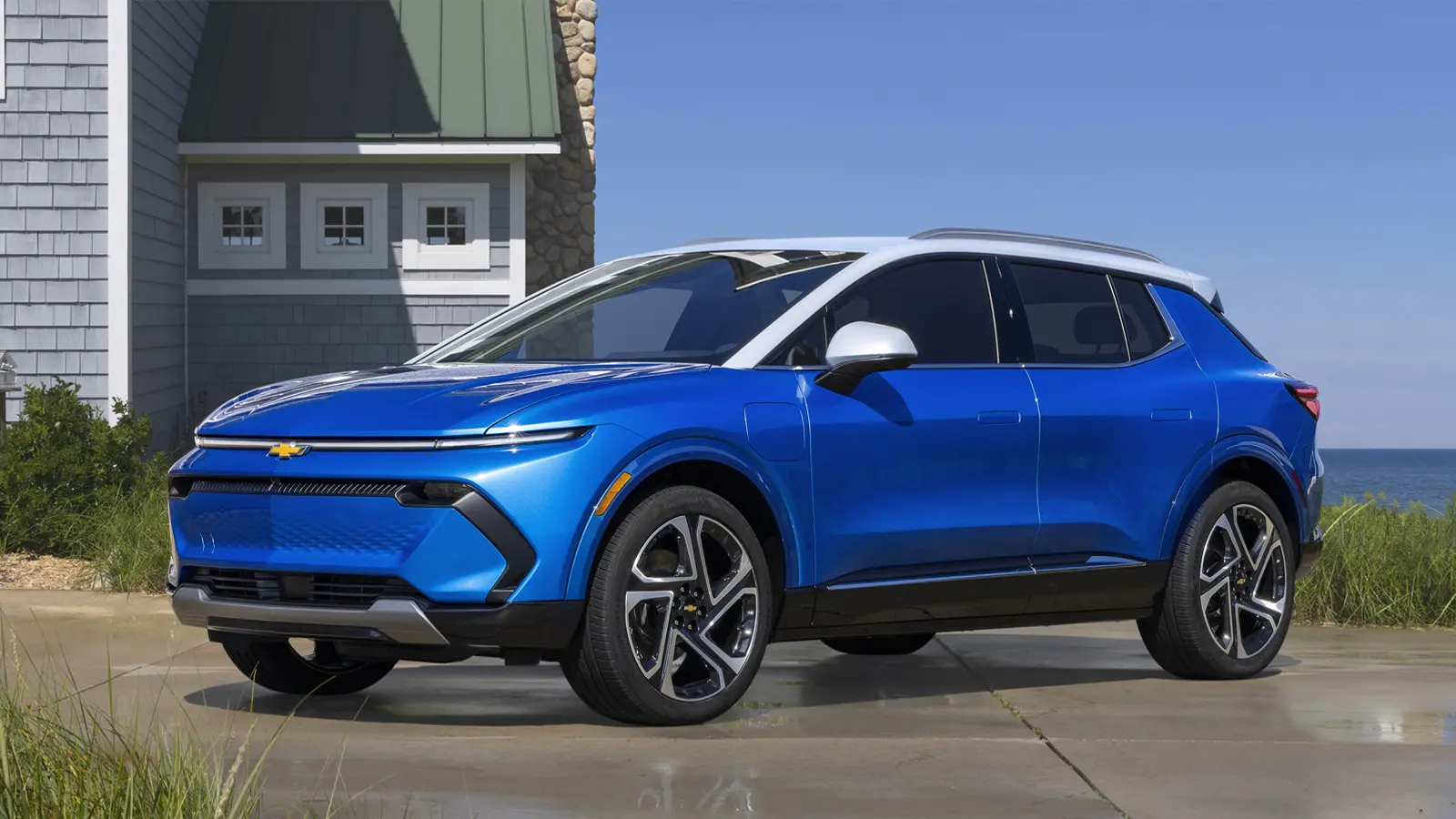 A blue 2024 Chevrolet Equinox EV by the water