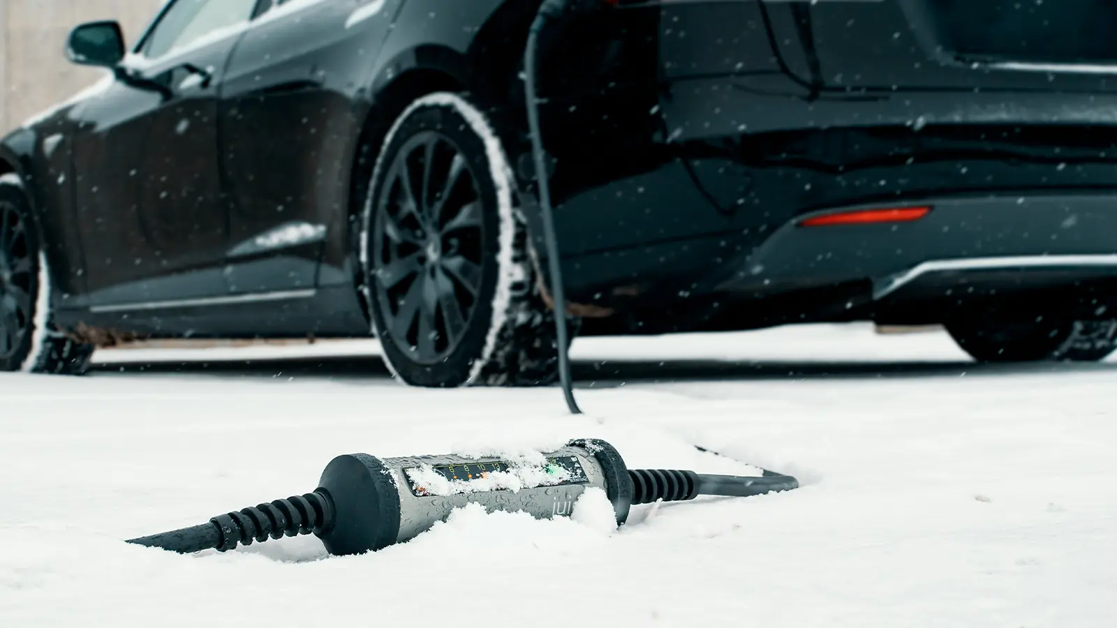 An EV charger laying in the snow