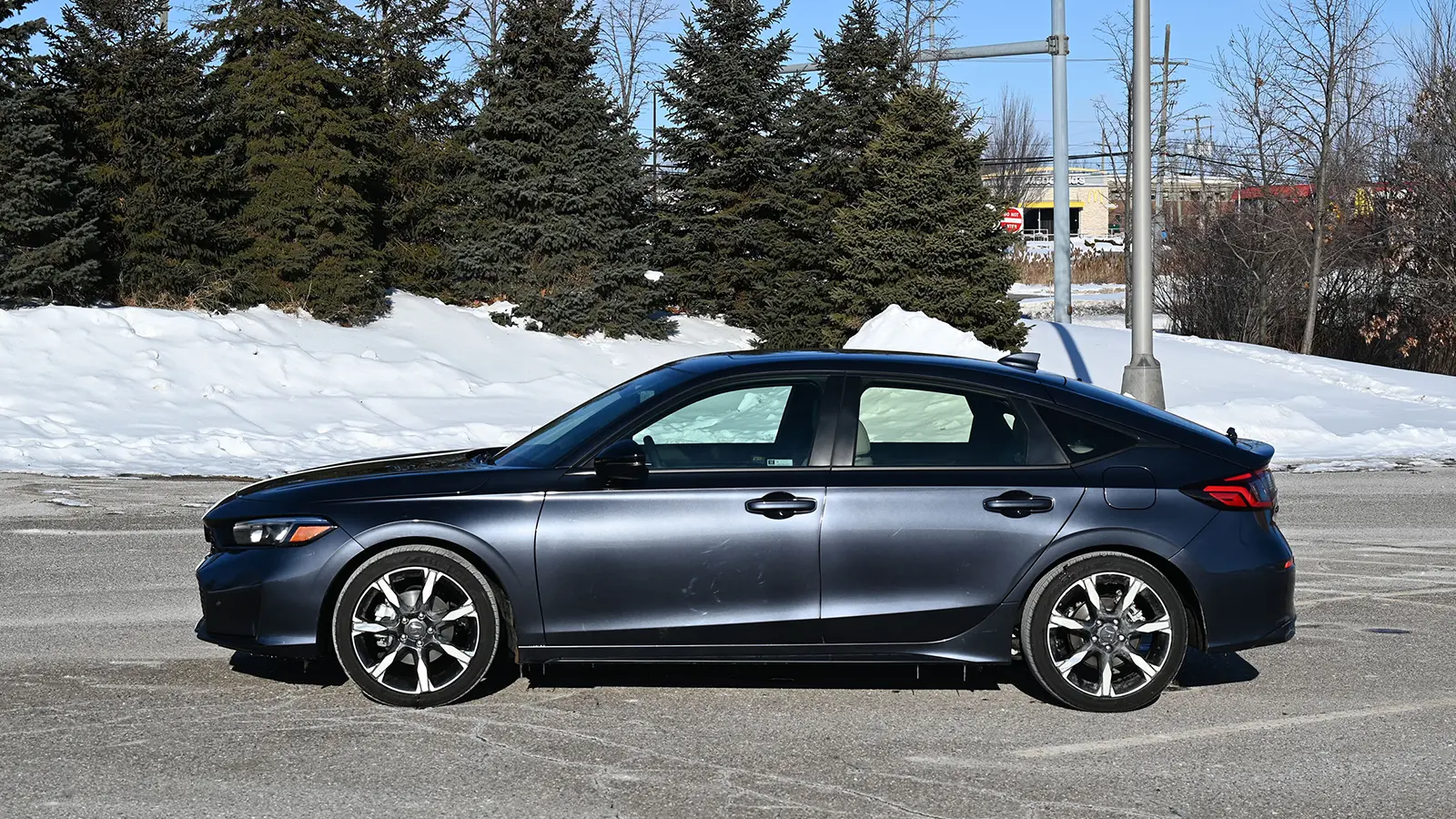 A dark blue 2026 Honda Civic Sport Touring Hybrid side view