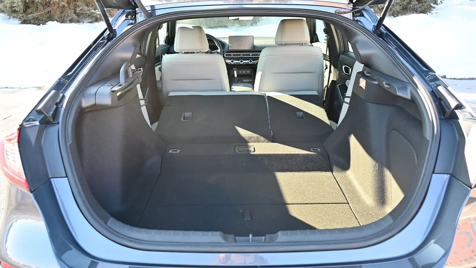 A dark blue 2026 Honda Civic Sport Touring Hybrid trunk open view