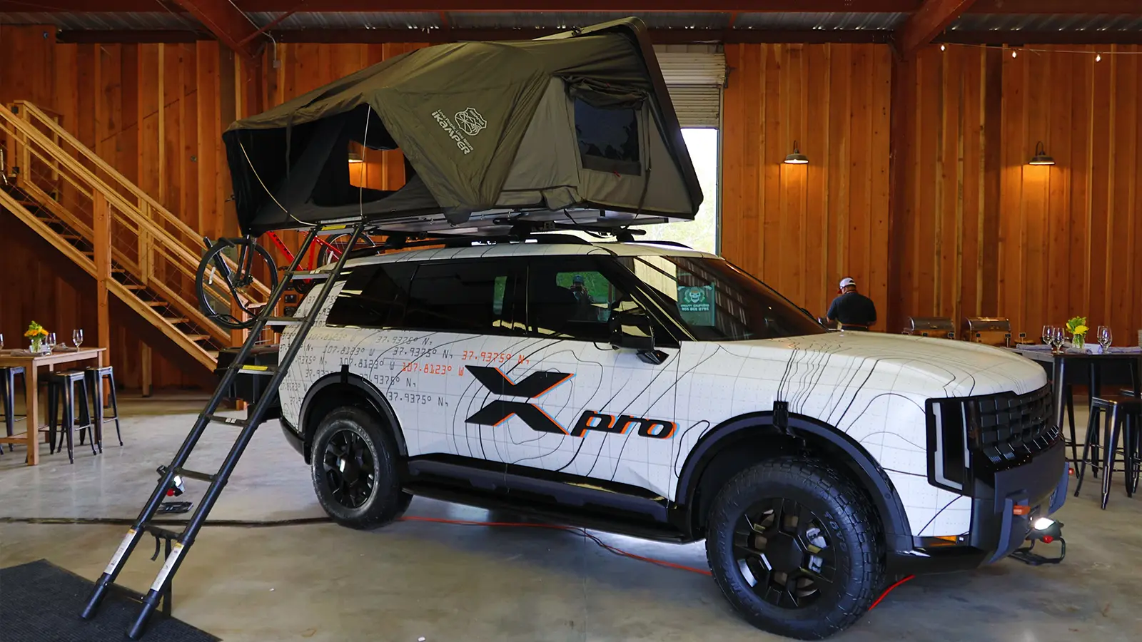 A 2027 Kia Telluride X Pro three quarter rear view with a camper top