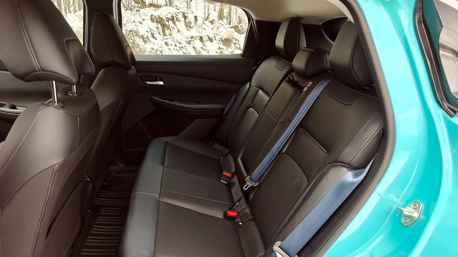 A teal 2026 Nissan Leaf interior rear seat side view