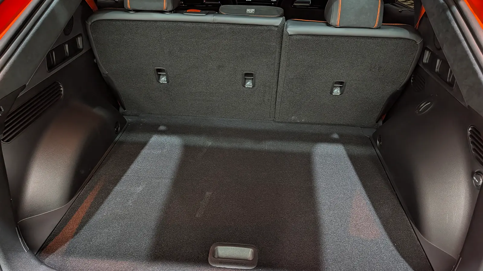 A 2027 Orange Genesis GV60 Magma interior rear cargo bay view lid open