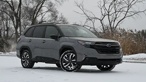 A dark grey 2025 Subaru Forester Touring Hybrid three quarter front view