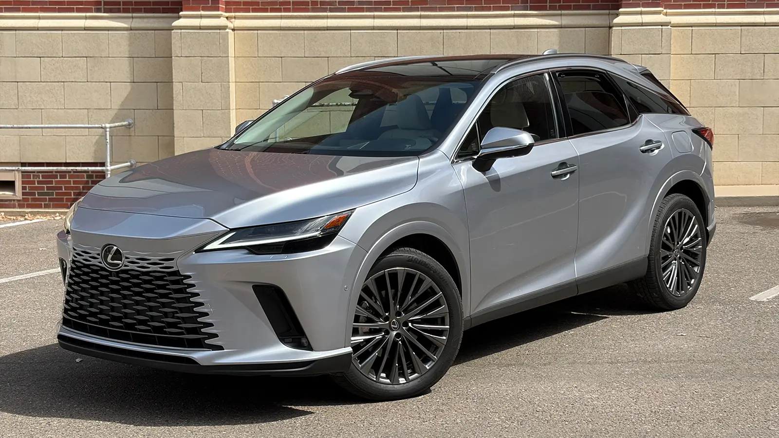 A silver 2026 Lexus RX 450h+ three quarter front view
