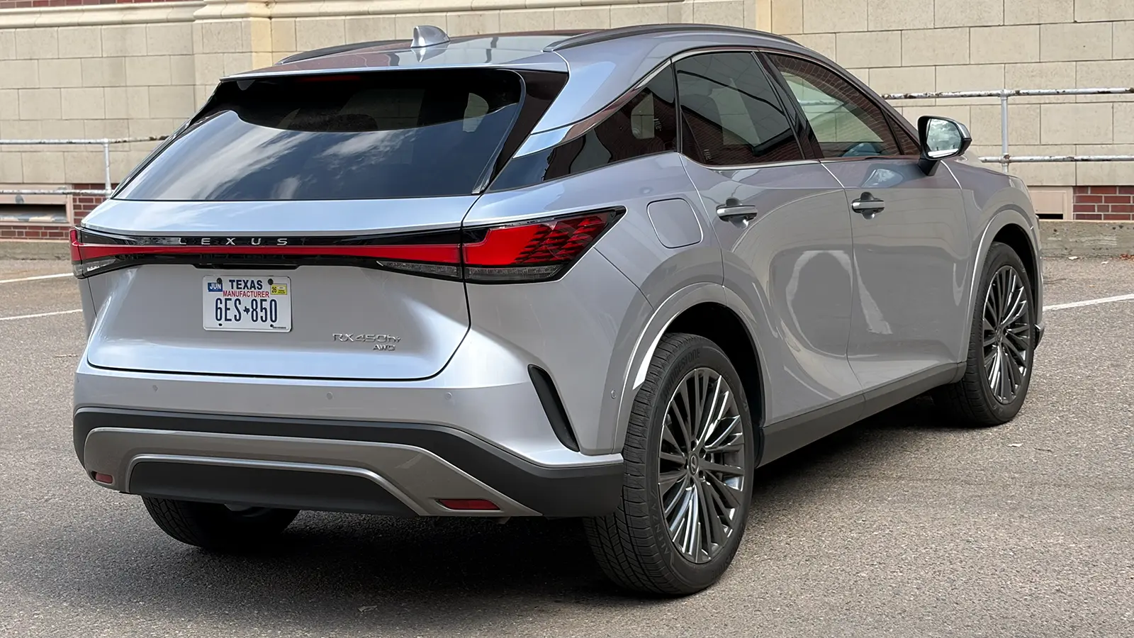 A silver Lexus RX 450h+ three quarter rear view