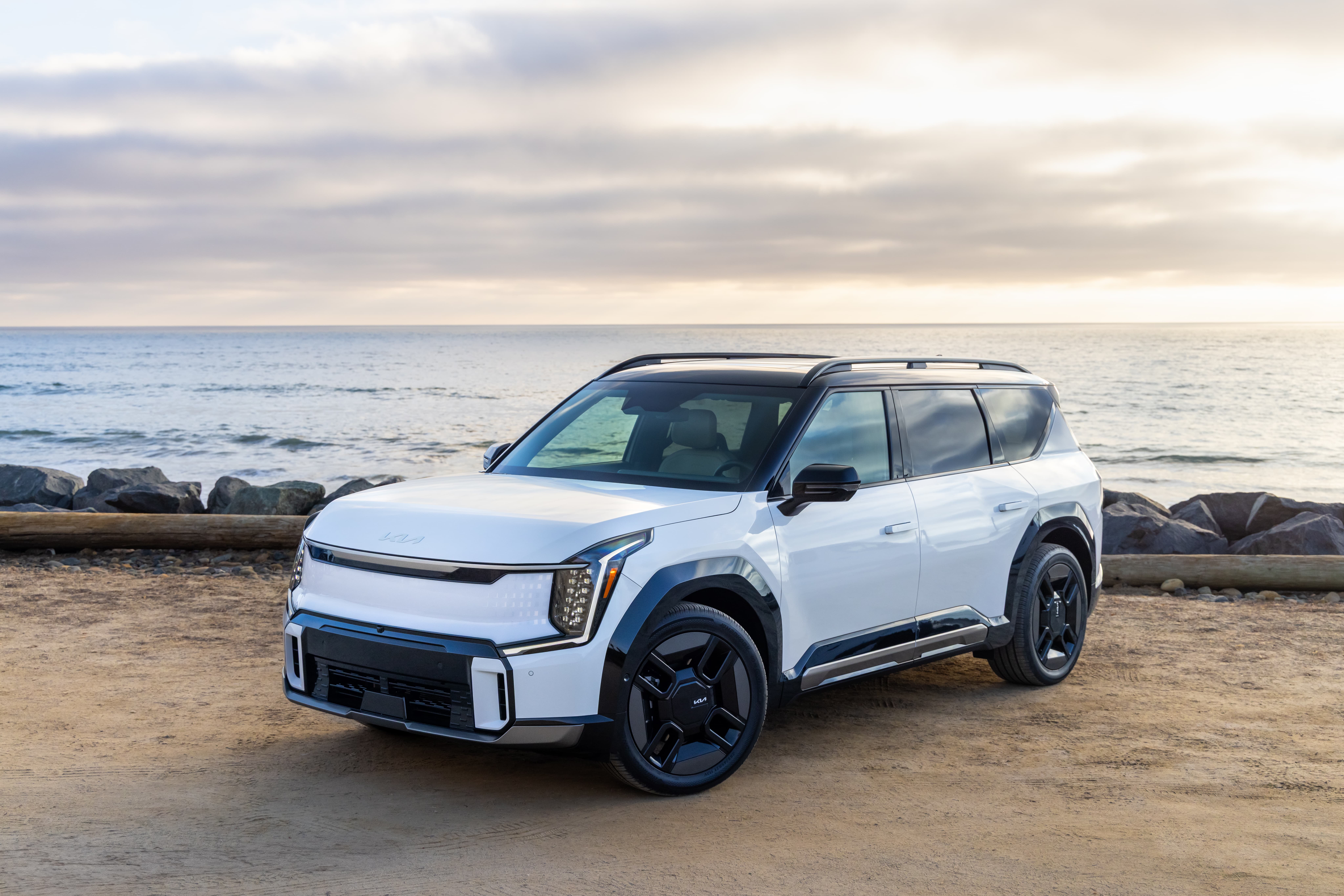 A white 2026 Kia EV9 parked at a waterfront