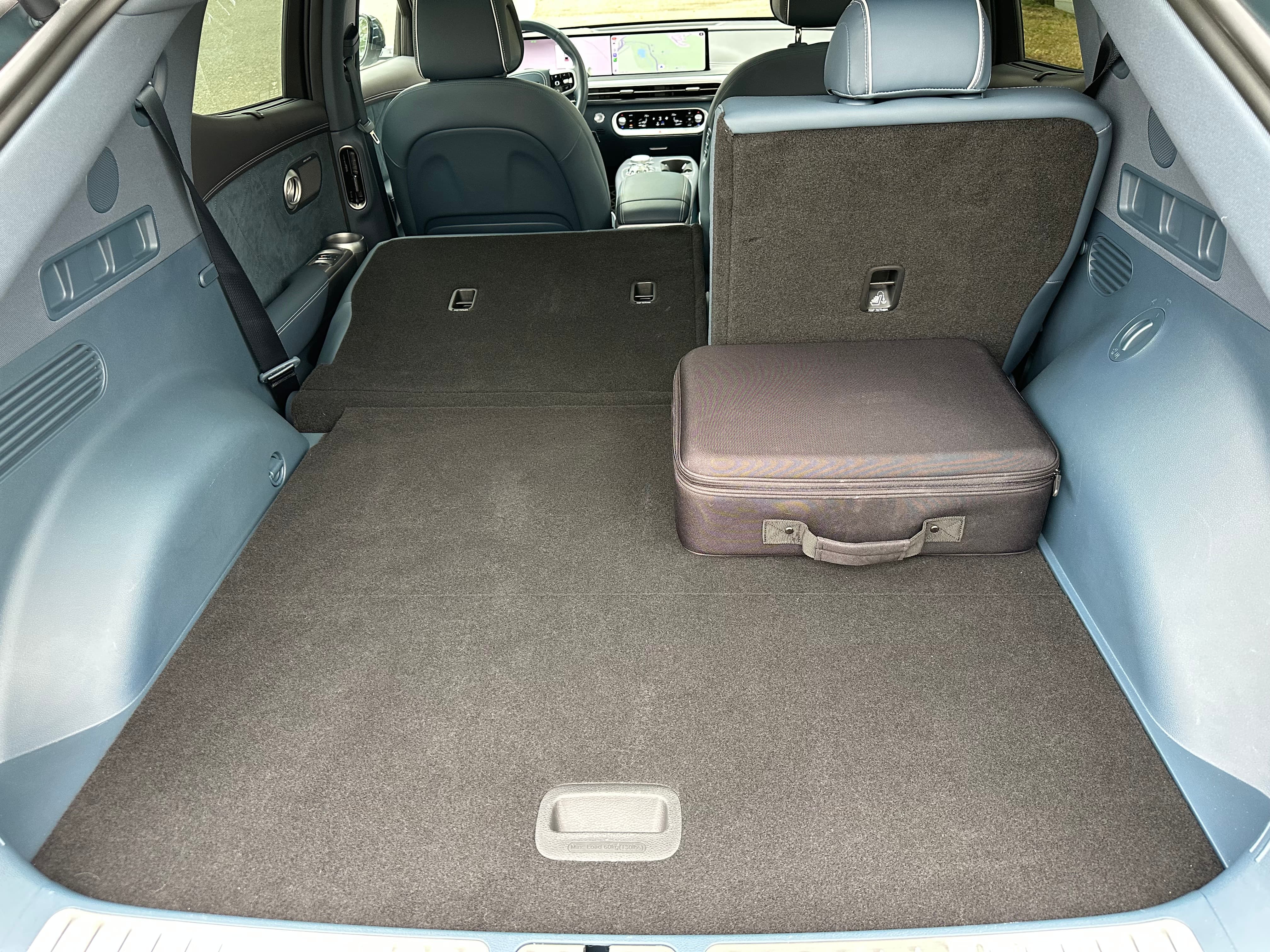 A 2026 Genesis GV60 rear interior view with the seat down
