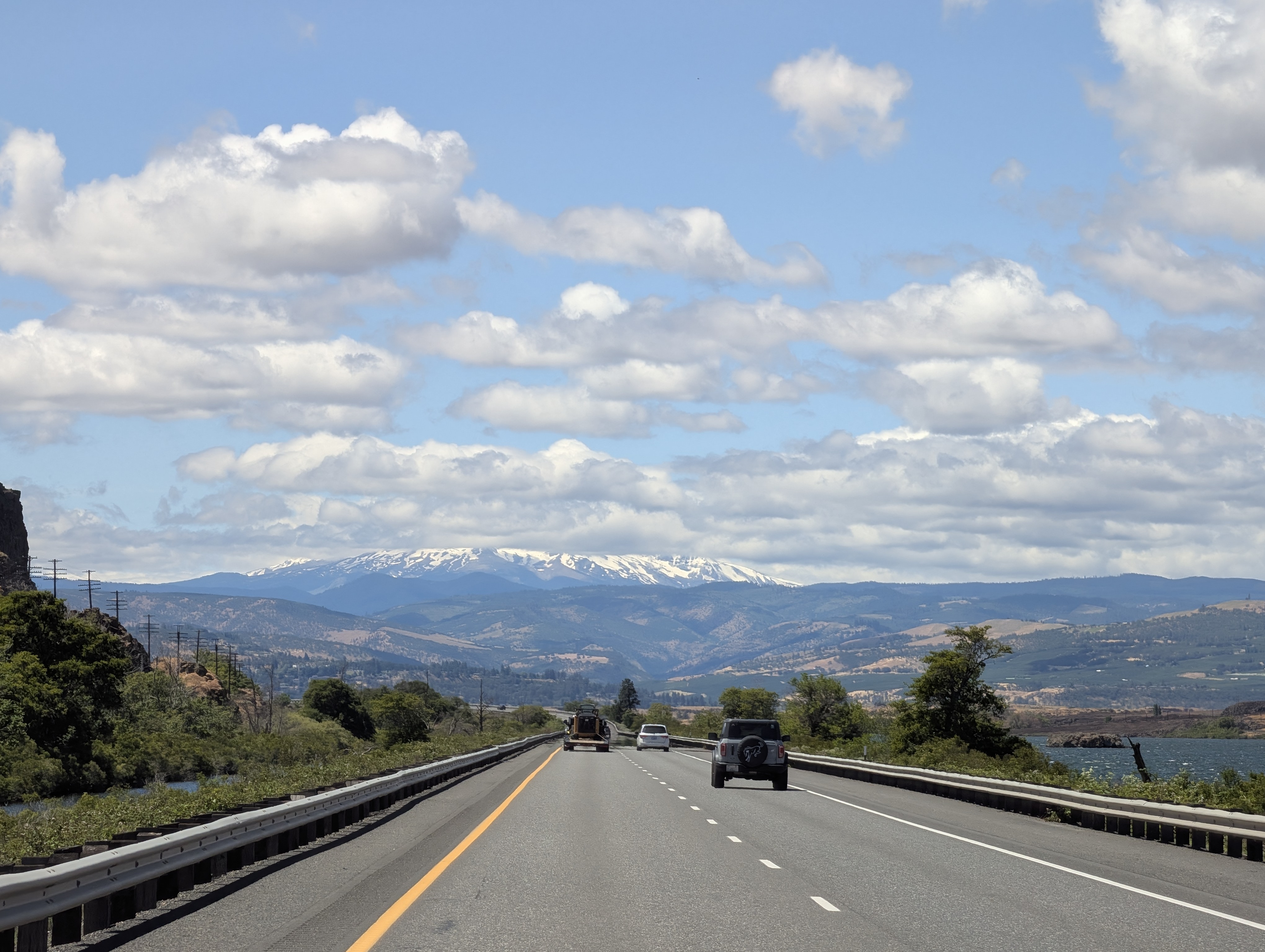 Open highway with cars and ice-capped mountains in the backdrop