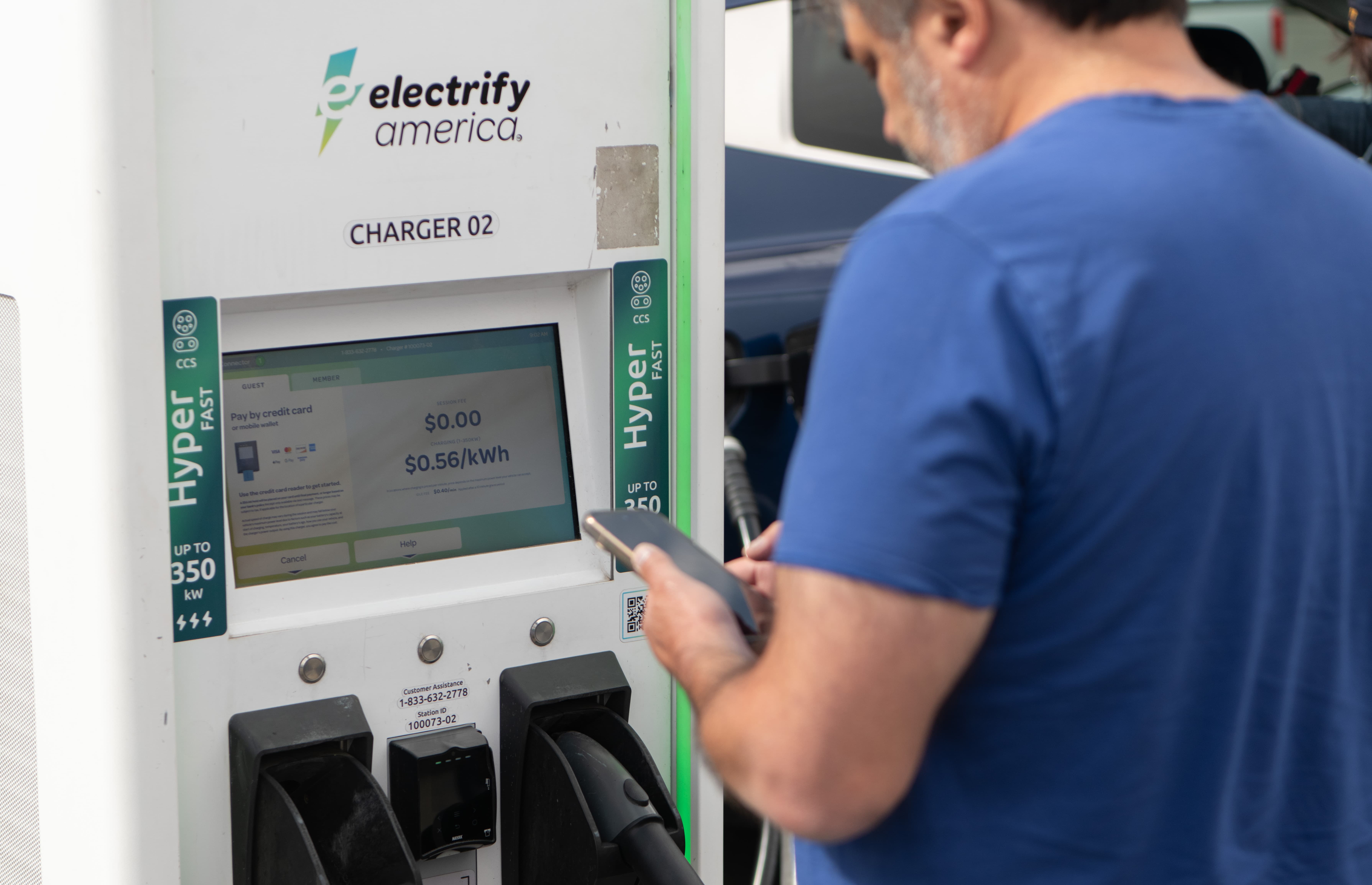 Man standing at the EV charging point to make payment