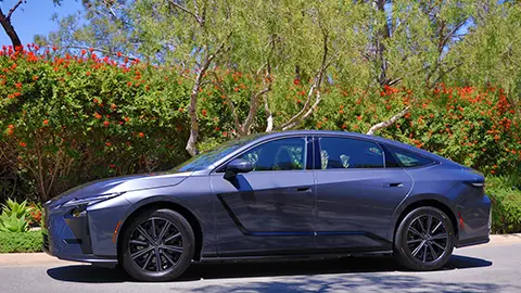 Lexus ES350e y ES500e Wavelength 2026 estacionados junto a un arbusto con flores rojas