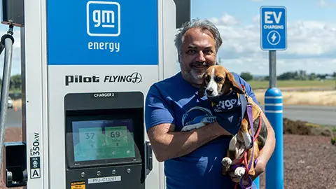 Sam Abuelsamid standing wit a Beagle next to an EV charging point