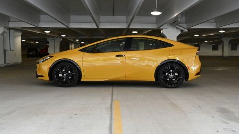 a gold hued yellow 2026 toyota prius nightshade edition plug-in hybrid parked in concrete structure