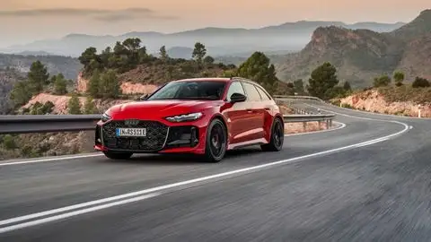 A current-gen red Audi RS 5 Avant on a winding road