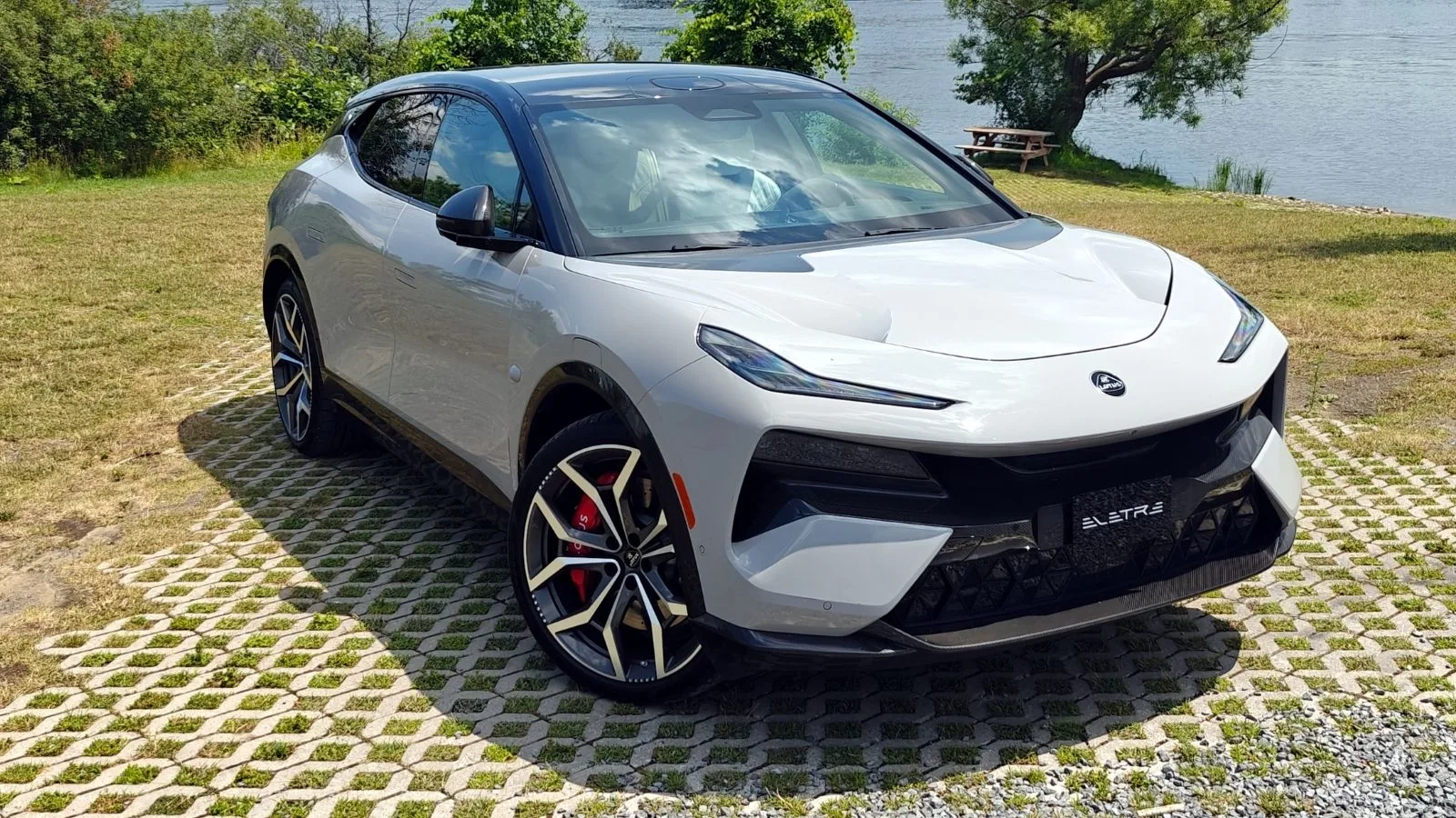 Silver 2026 Lotus Eletre sitting at an angle on broken concrete in front of a body of water