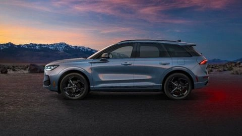 Vista de perfil del Lincoln Corsair Hybrid 2027 en color plata, con un terreno montañoso de fondo al atardecer. 
