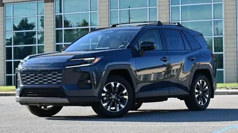 2026 Toyota RAV4 angled sitting in a parking lot in front of a mirrored building