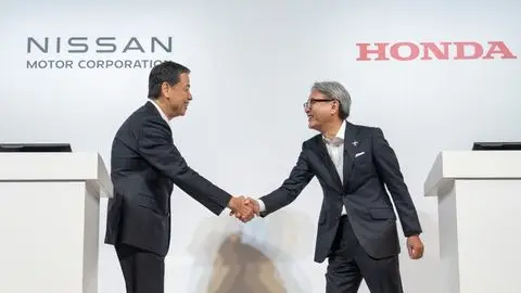 Photo from Nissan and Honda Joint Press Conference of Executives shaking hands