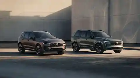 Los nuevos Volvo XC60 y Volvo XC90 estacionados en ángulo frente a un edificio de hormigón