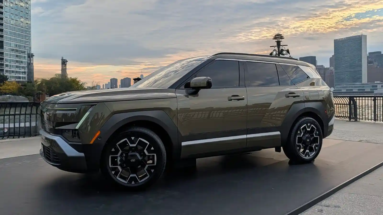 The all-new 2027 Hyundai Tucson Hybrid in a green exterior color parked with the New York City skyline in the background