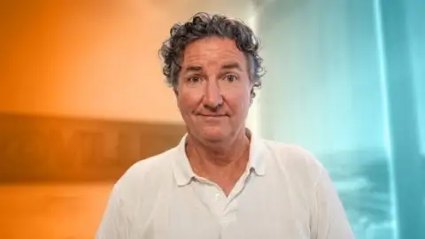 Headshot of James Bell, Kia America's Head of Corporate Communications, on a orange and blue faded background