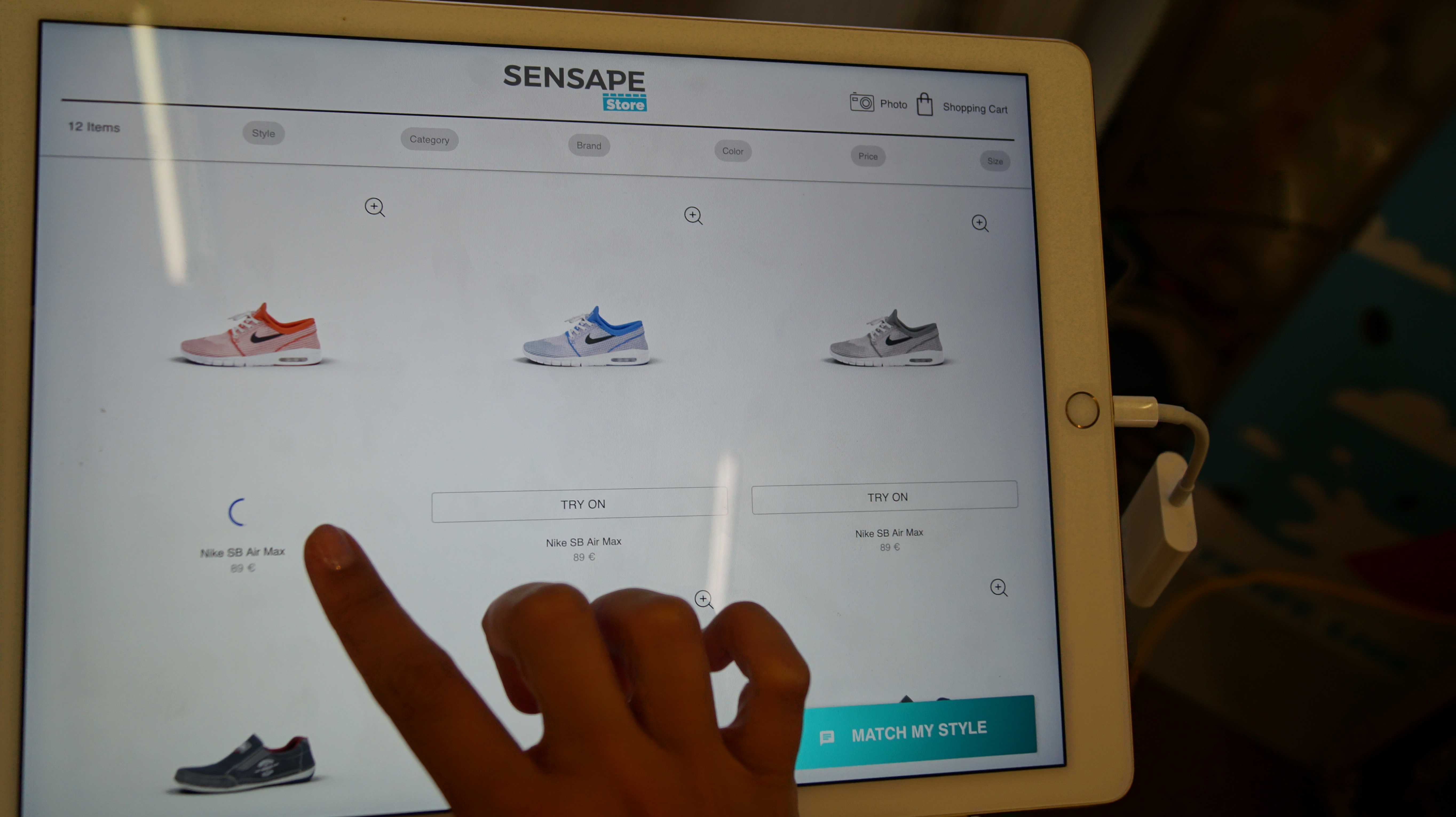 Sensape Virtual Try-On for footwear – customer selecting sneakers on a touch tablet at the point of sale