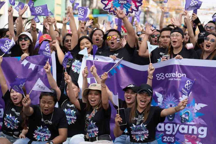 Carelon Global Solutions Philippines employees cheer with Carelon flags and banners at the Dinagyang Festival in Iloilo City
