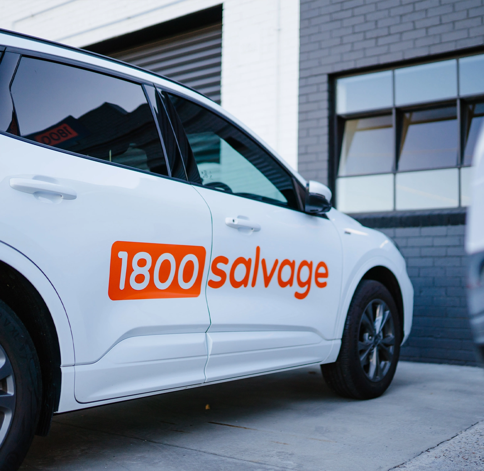 White car branded with the 1800 Salvage logo.