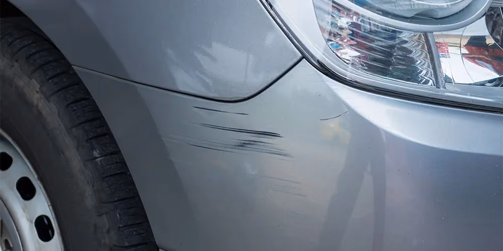 Silver-grey car with a mildly scratched front bumper.