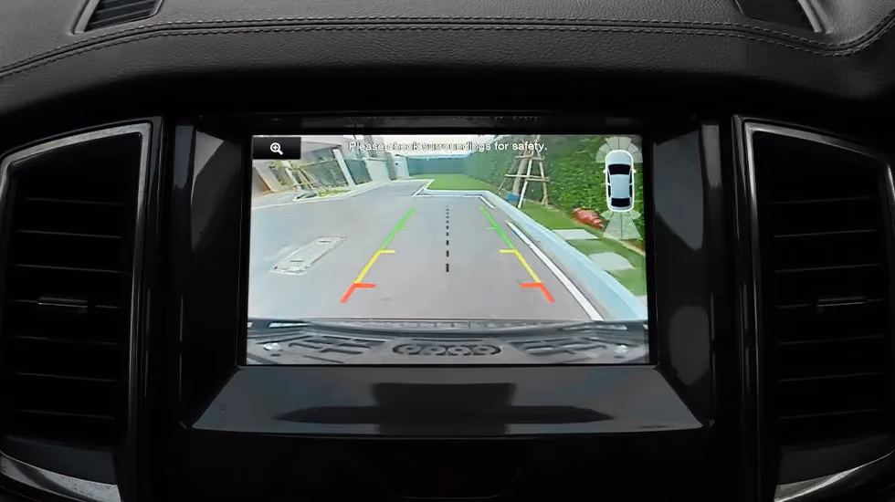 A car’s dashboard screen displays the rear view camera. These screens can be removed and recycled.