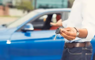 Person holding car keys in front of a blue vehicle, showing the best way to sell a car in Canberra and get a fair price quickly with a smooth handover.