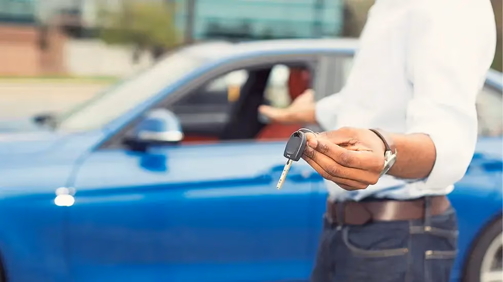 Person holding car keys in front of a blue vehicle, showing the best way to sell a car in Canberra and get a fair price quickly with a smooth handover.