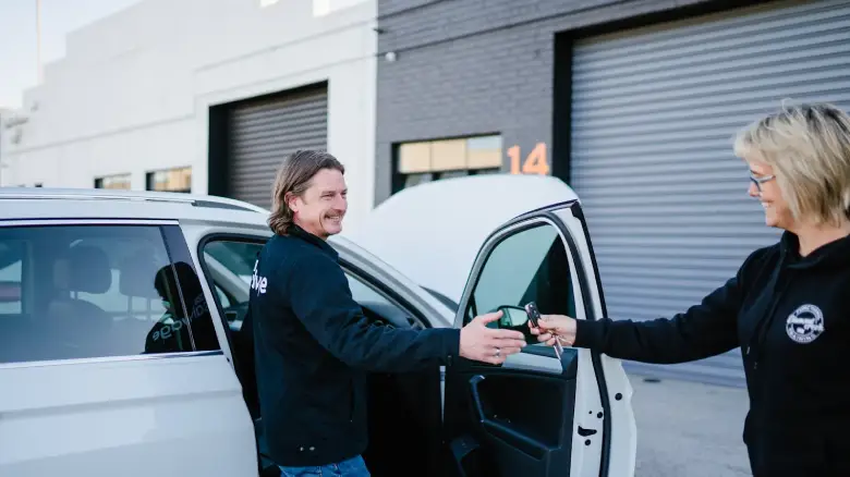 Customer handing over car keys in Canberra after selling a car through a hassle-free service, showing how easy it is to sell your car in Canberra with paperwork completed.