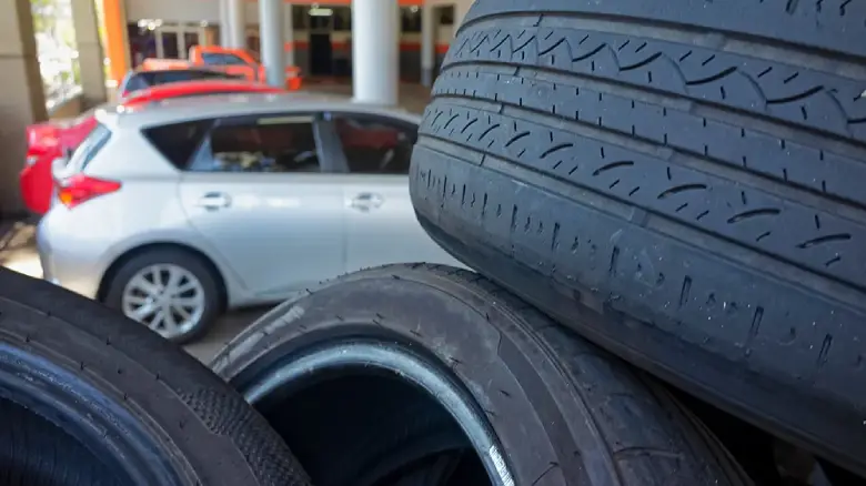 Used tyres and older car in Adelaide, symbolising damaged or unregistered vehicles that 1800 Salvage buys.