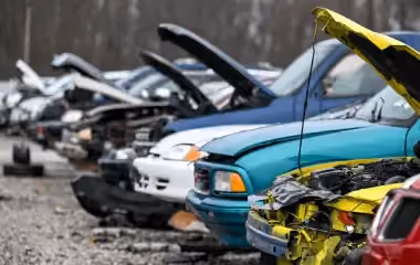 Row of scrap cars in Darwin at a wrecking yard, showing unwanted vehicles ready for recycling and car removal services.