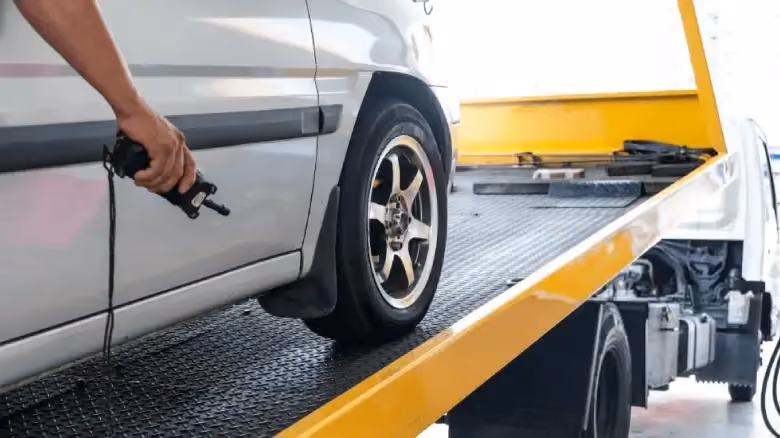 Car removal service in Darwin loading a vehicle onto a tow truck for scrap car recycling and cash for cars pickup.