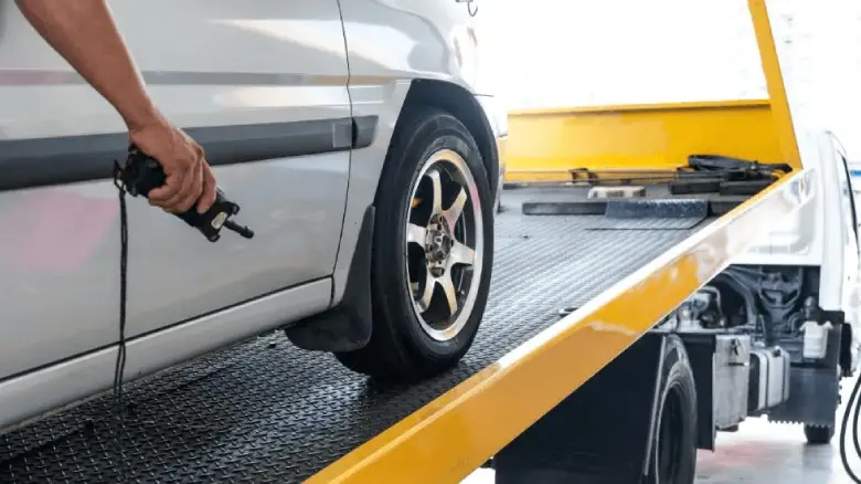 Car removal service in Darwin loading a vehicle onto a tow truck for scrap car recycling and cash for cars pickup.